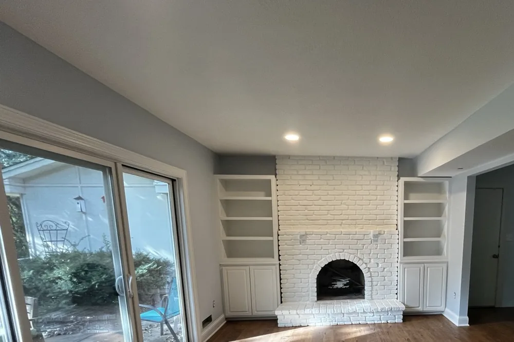 Living room repainted by Smooth Painting with white brick fireplace and built-in shelving